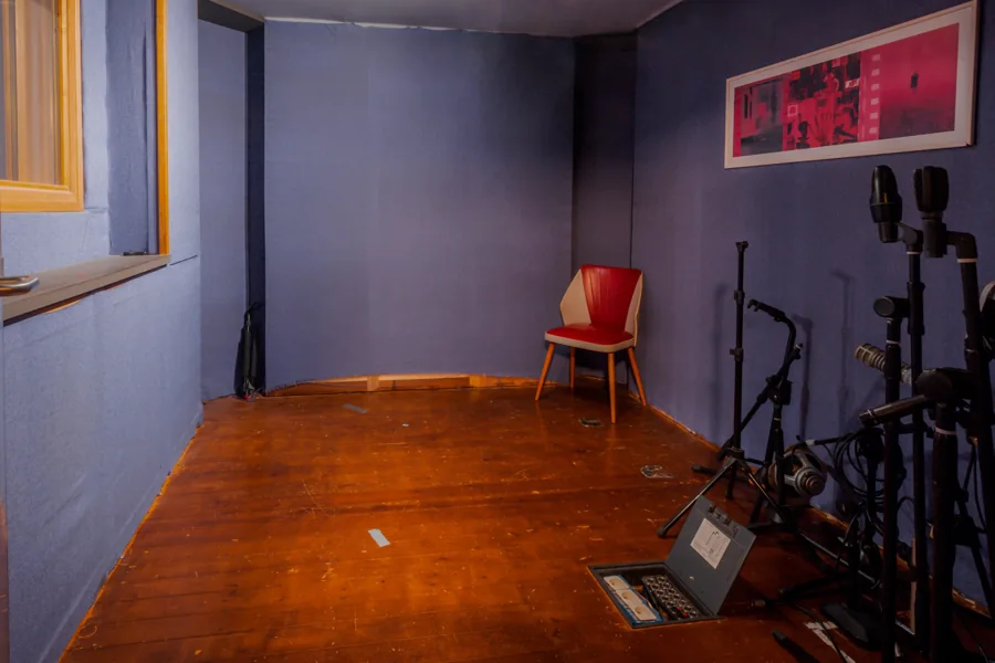 Opnameruimte met paarse akoestische wanden, een houten vloer en instrumentstandaards